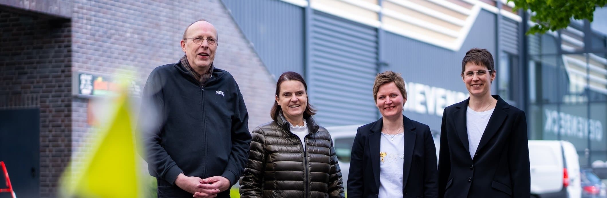 Das Team steht vor einem Gebäude